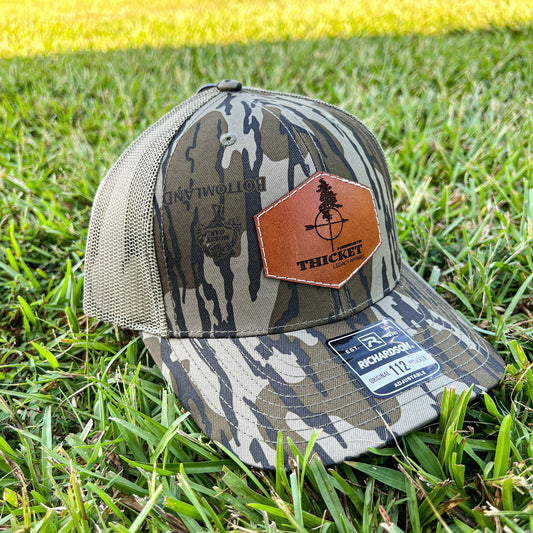 THICKET Logo Leather Patch Trucker Hat | Mossy Oak® Bottomland Camo